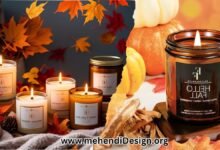 Best fall candles arranged in a cozy display with autumn leaves, a warm blanket, and softly glowing, fall-scented candlelight.
