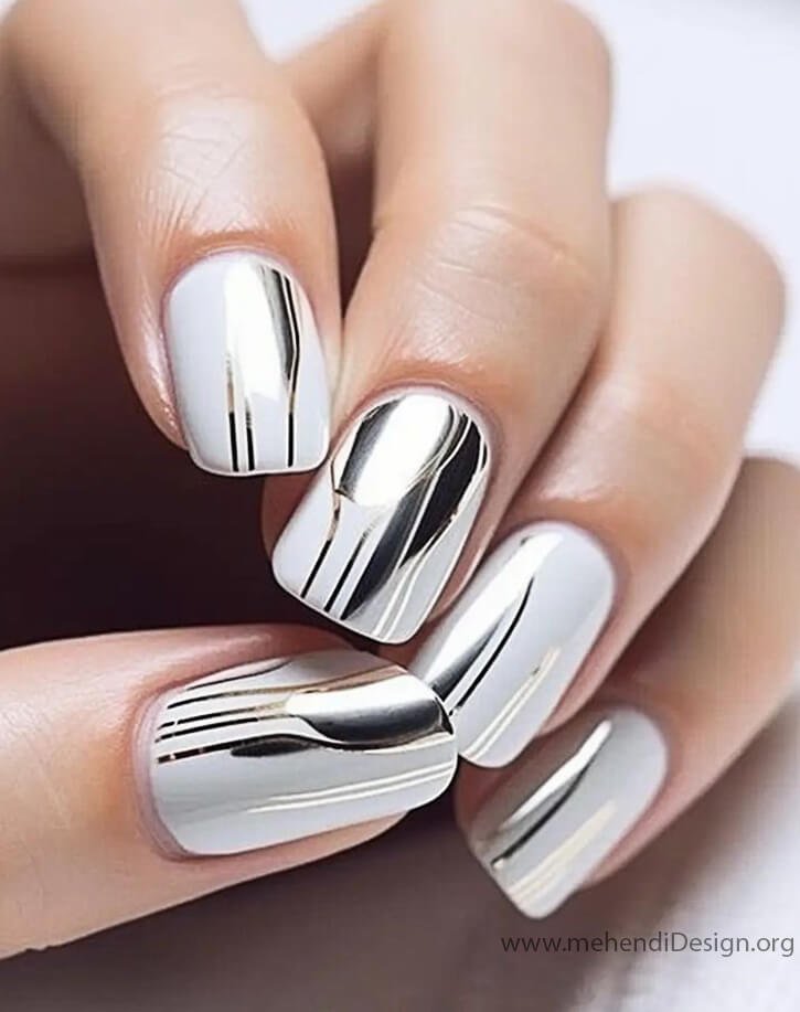 Image of A modern manicure with metallic silver foil stripes on a white base A modern manicure with metallic silver foil stripes on a white base
