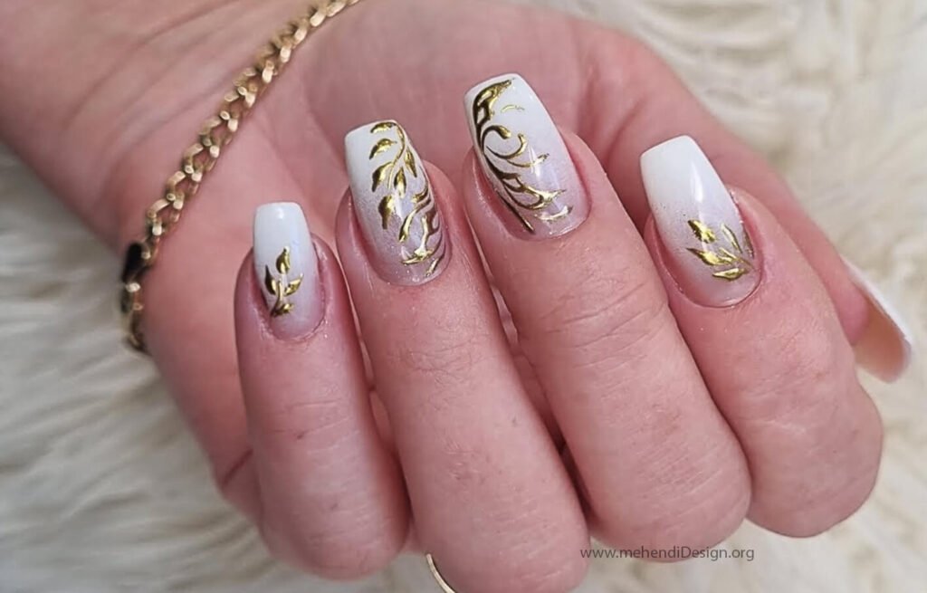 Image of An elegant white manicure with a luxurious gold leaf accent nail An elegant white manicure with a luxurious gold leaf accent nail